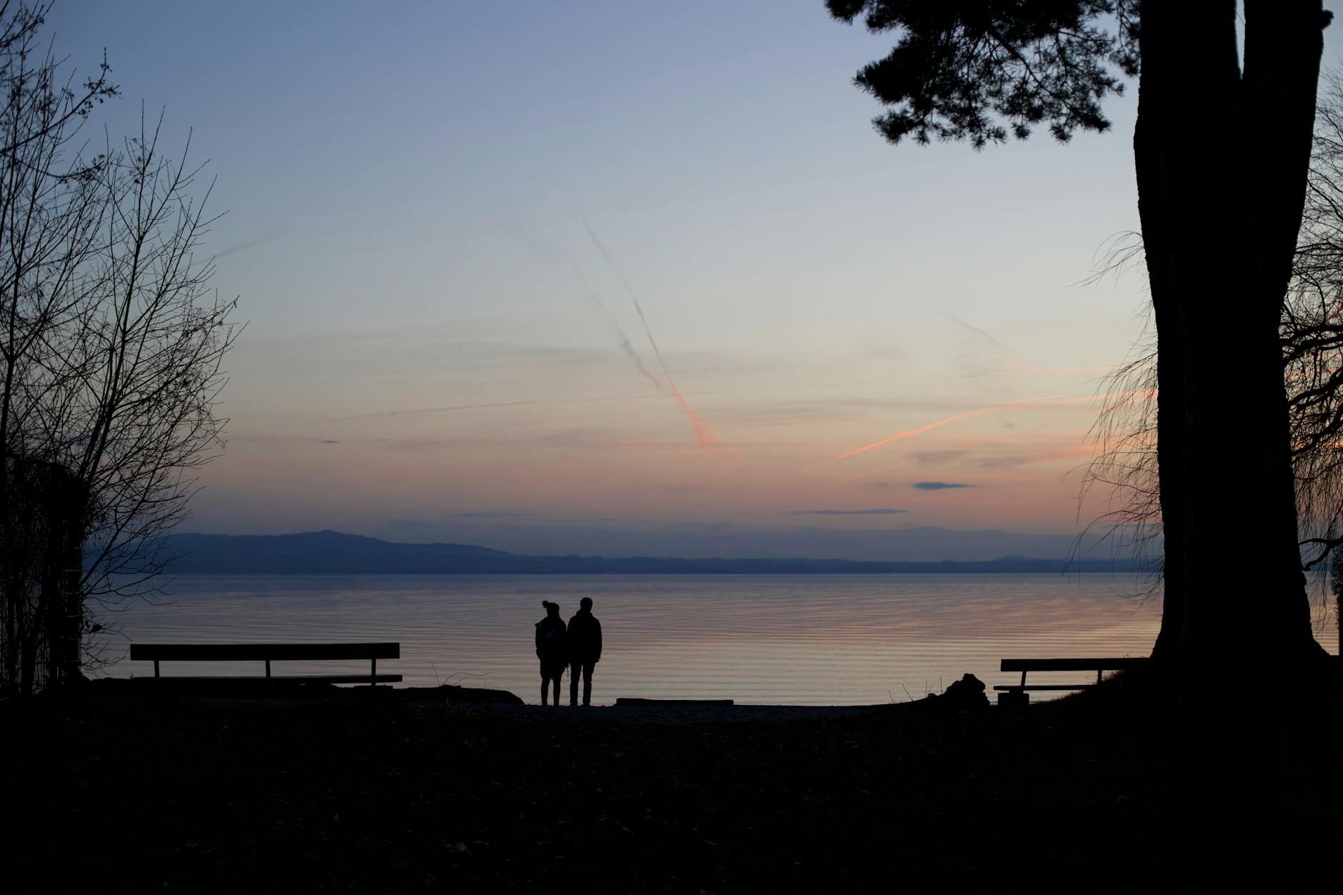 Couple Watching Dusk By Ocean