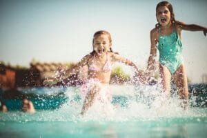 Two Girls Running Into A Pool