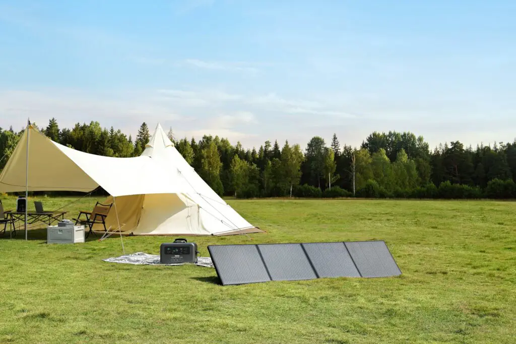 A Tent And Solar Panel In A Field