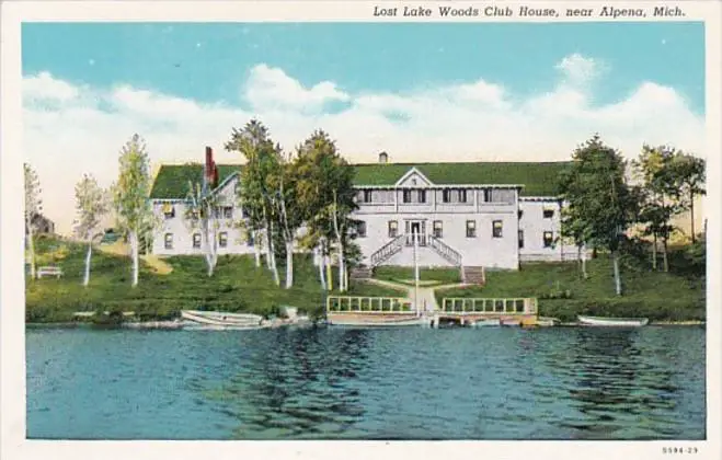 A Large White Building With Trees And A Body Of Water