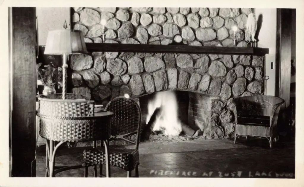 A Fireplace With A Table And Chairs