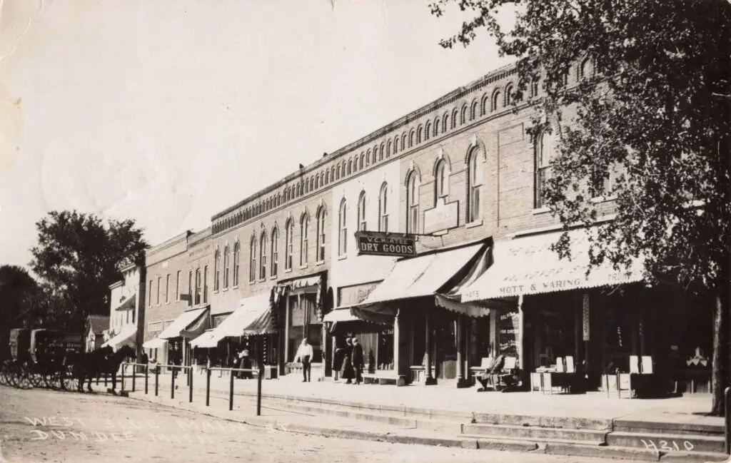 A Black And White Photo Of A Building With Shops On The Side