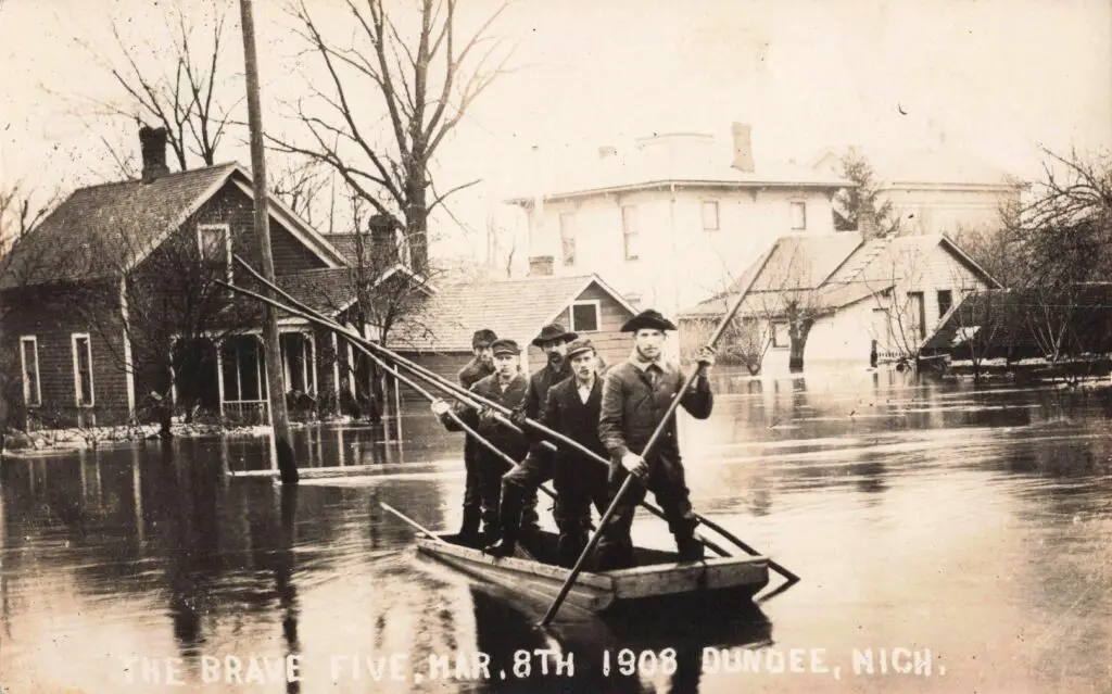 A Group Of Men In A Boat In Flood Waters