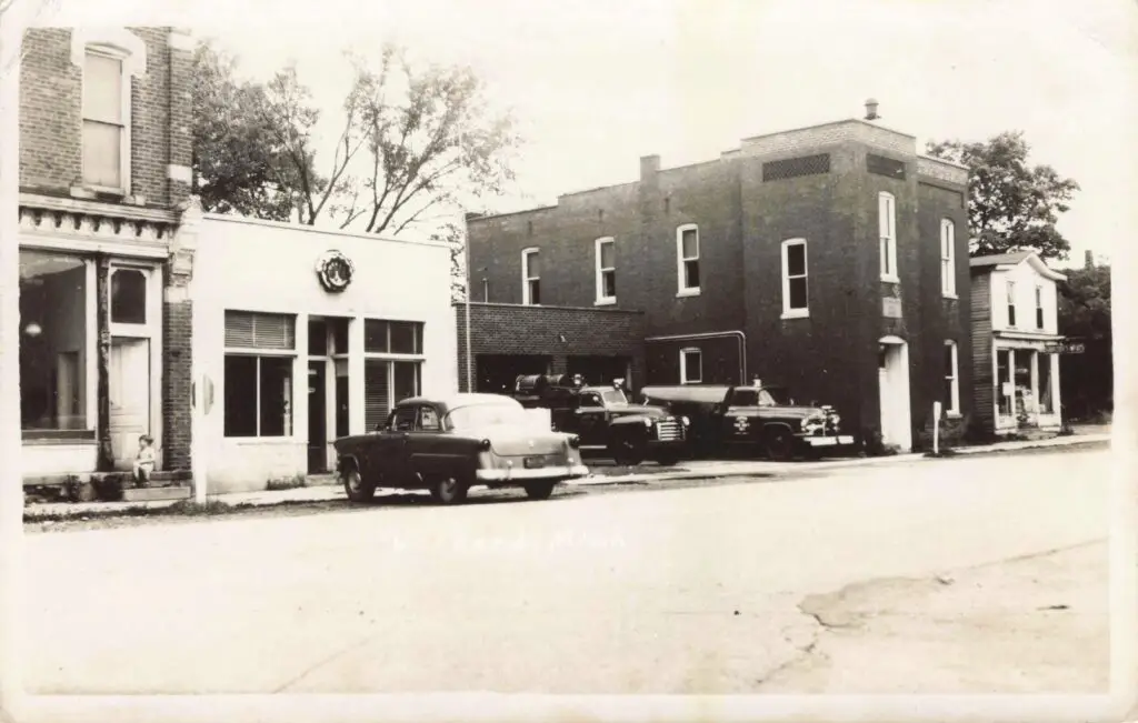 A Black And White Photo Of A Building With Cars Parked Outside