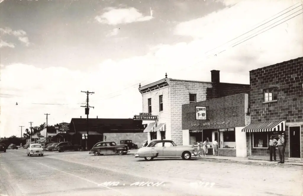 A Black And White Photo Of A Street With Cars And Buildings