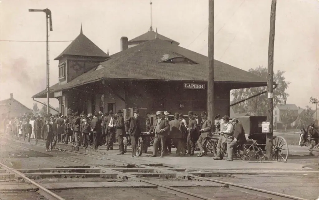 A Group Of People Standing On Train Tracks
