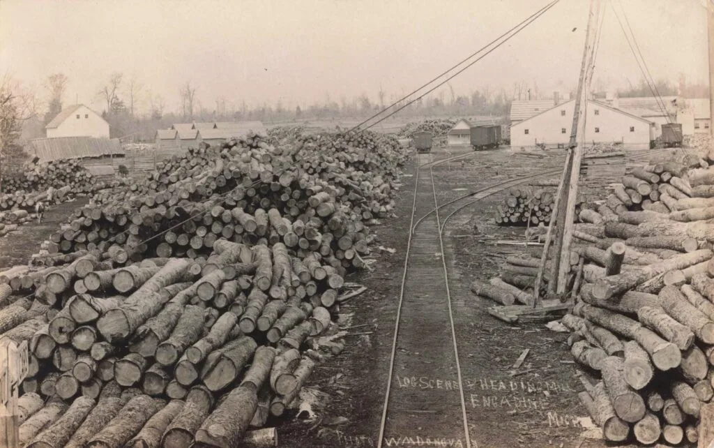A Train Tracks With Logs Stacked On Each Other - History Of Engadine Michigan