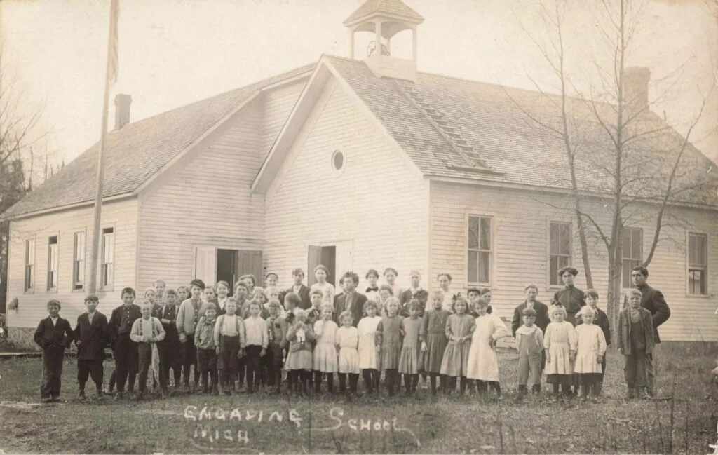 A Group Of People Standing In Front Of A School Building