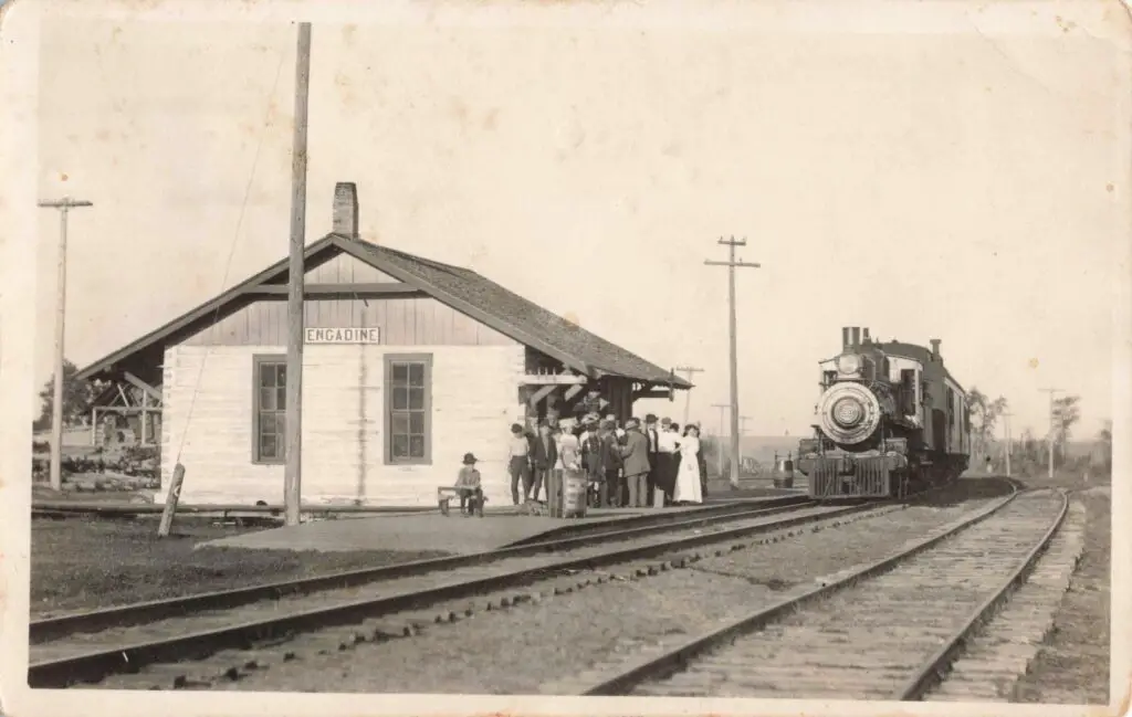 A Group Of People Standing Next To A Train
