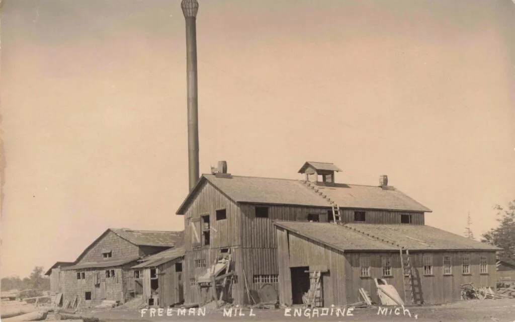 A Group Of Buildings With A Tall Chimney