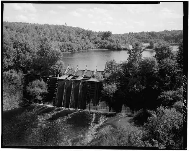 A Dam With A River And Trees