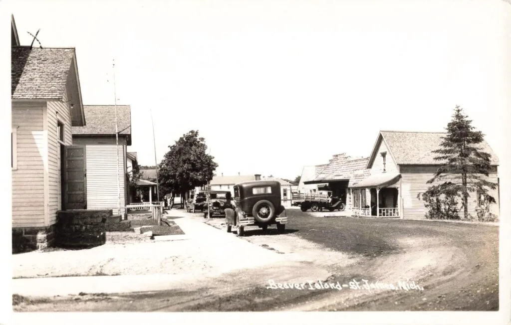 A Black And White Photo Of A Street With Houses And A Truck