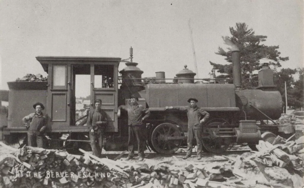 A Group Of Men Standing Next To A Train
