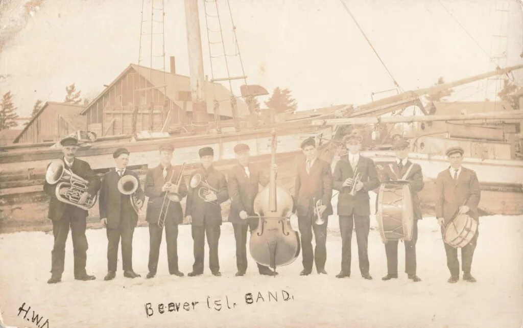 A Group Of People Standing In Front Of A Boat