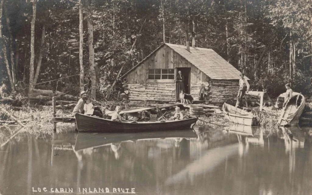 People By A Cabin Near Water.
