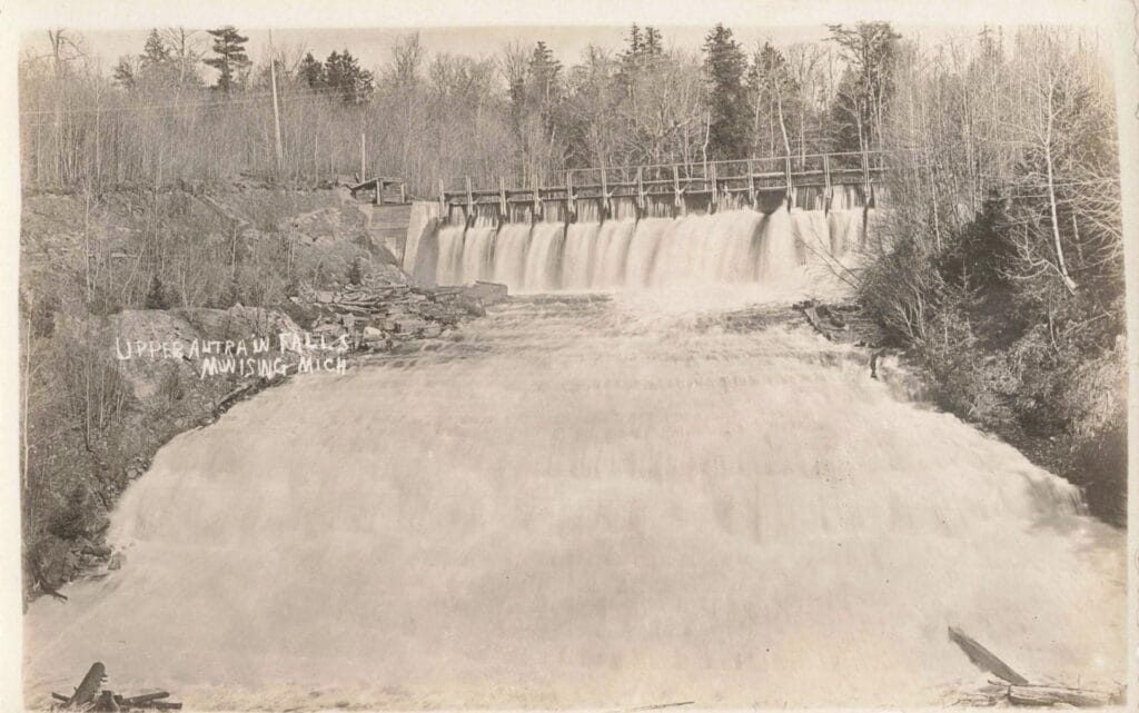 Historic Waterfall With Dam And Trees.