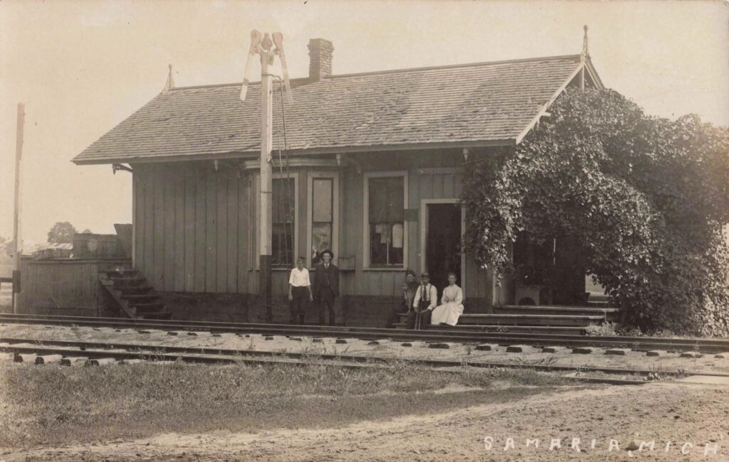 Old Train Station With People Sitting.