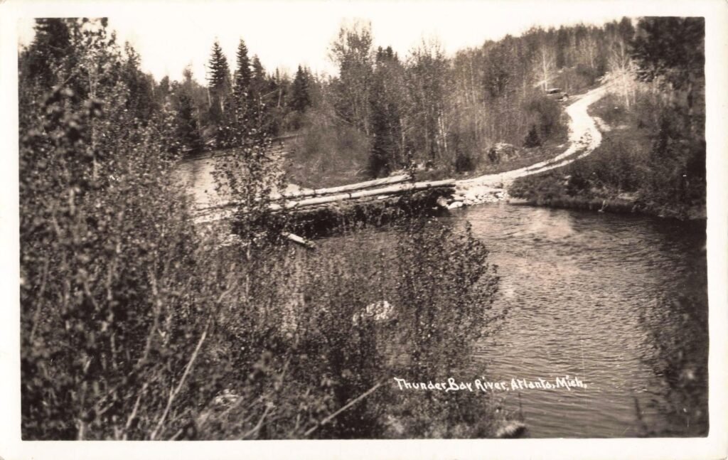 Scenic River With Bridge And Trees.