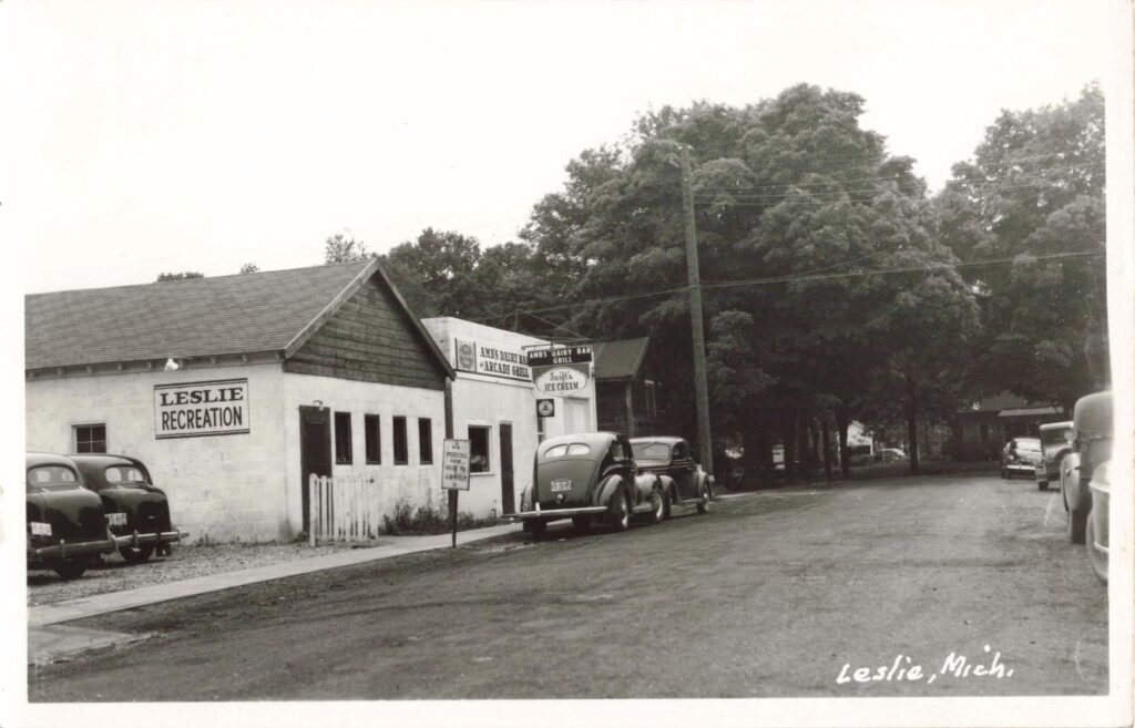 Vintage Cars Parked Outside Ambs Dairy Bar And Leslie Recreation Building In Mid-20Th Century Leslie Michigan.
