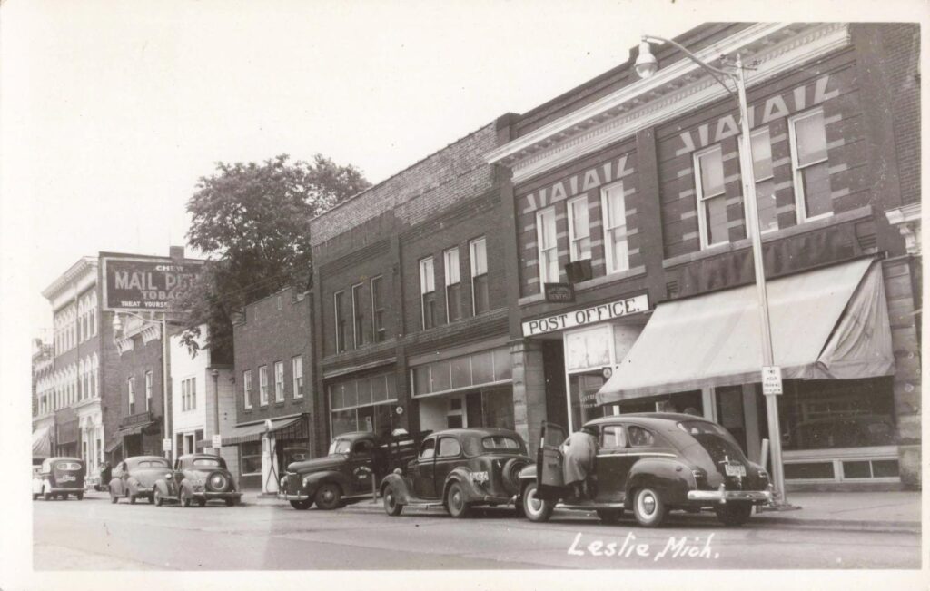 1930S Downtown Leslie Michigan With Parked Automobiles And Brick Commercial Buildings