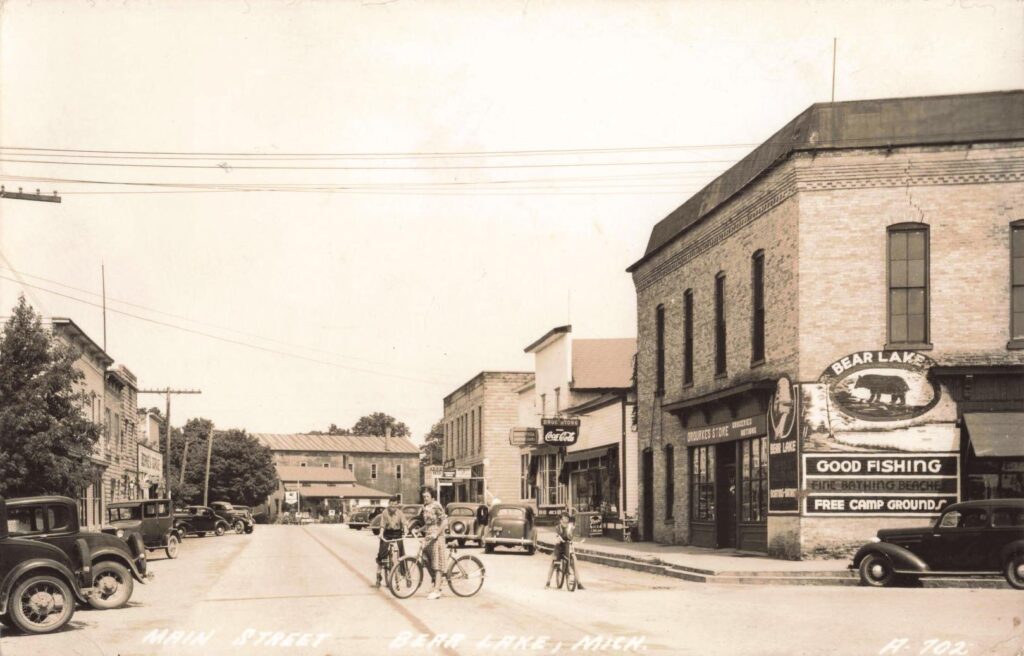 Main Street, Bear Lake, Mich. Signs Advertise Fishing, Bathing, And Free Campgrounds—Key Draws For Visitors.