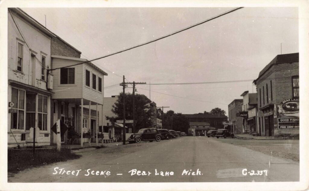 Street Scene – Bear Lake, Mich. Overhead Lines And Parked Cars Show A Town Adapting To Modern Infrastructure.