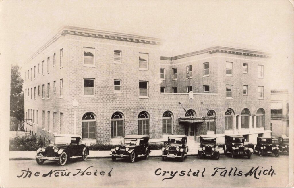 Historic Hotel With Vintage Cars Outside.