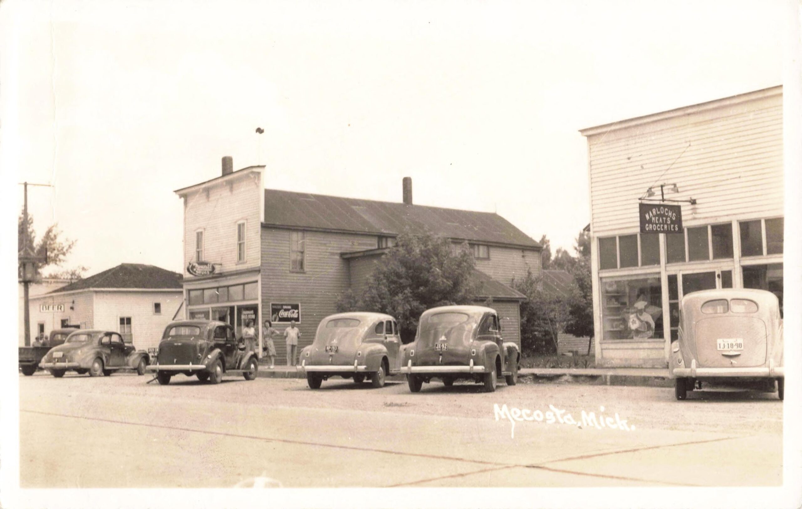 Cars Parked Along Mecosta's Business Street Near Harlock's Grocery And Fairman's Drug Store