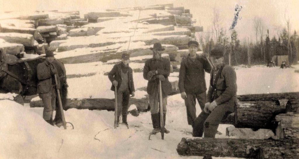 Men Logging In Snowy Landscape.